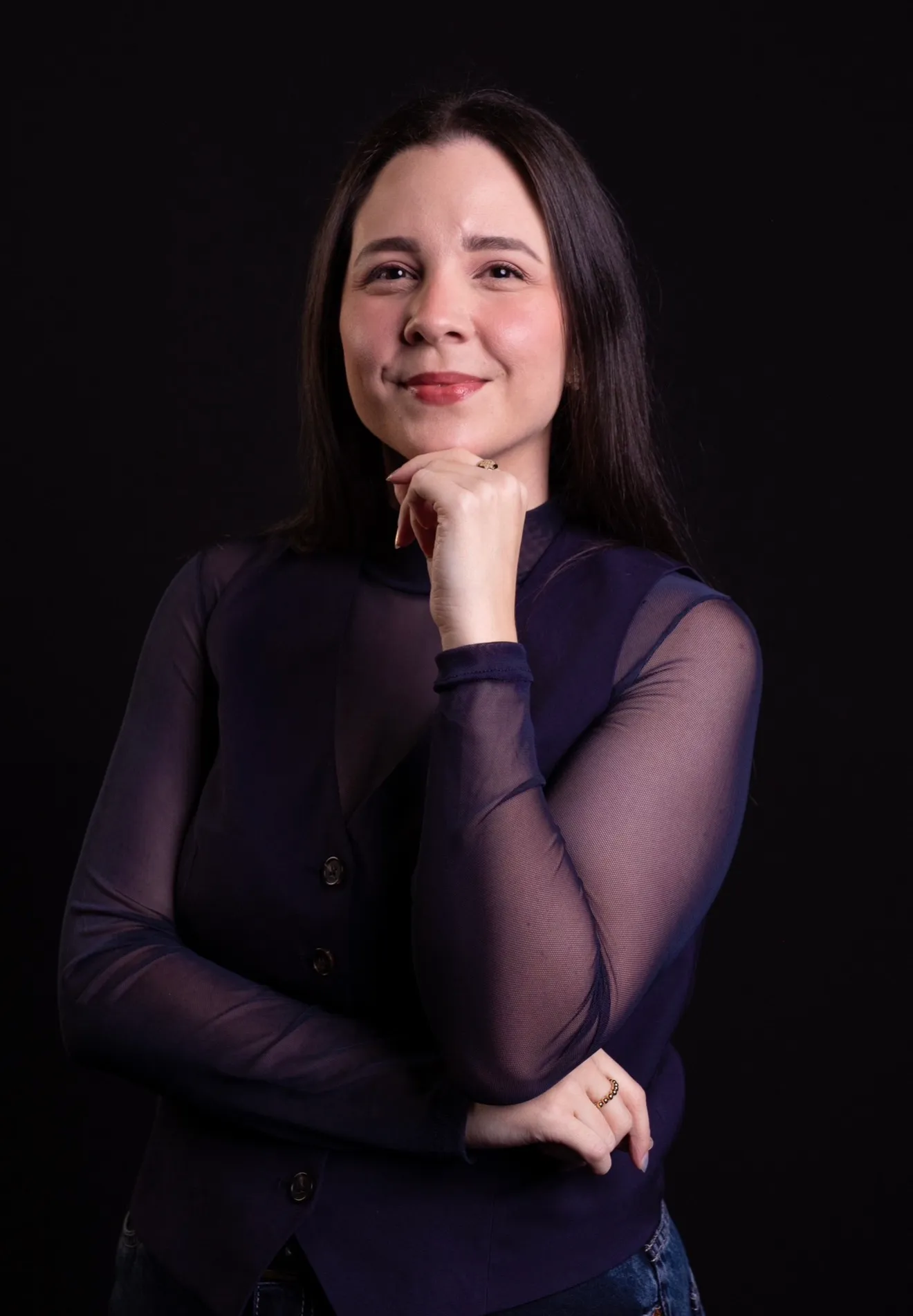 Retrato da Dra. Vitória Rollim sorrindo, com a mão no queixo
